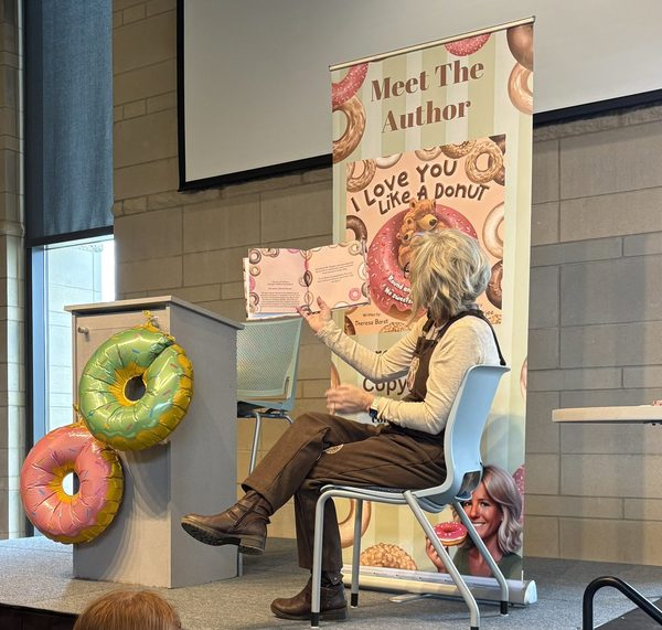 Theresa Borst reading to a large group of elementary students during an author visit