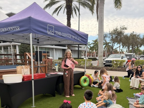 Theresa sharing storytime with children and families at a community event in the park